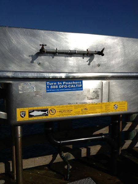 Dockside cleaning station with poaching-hotline signage
