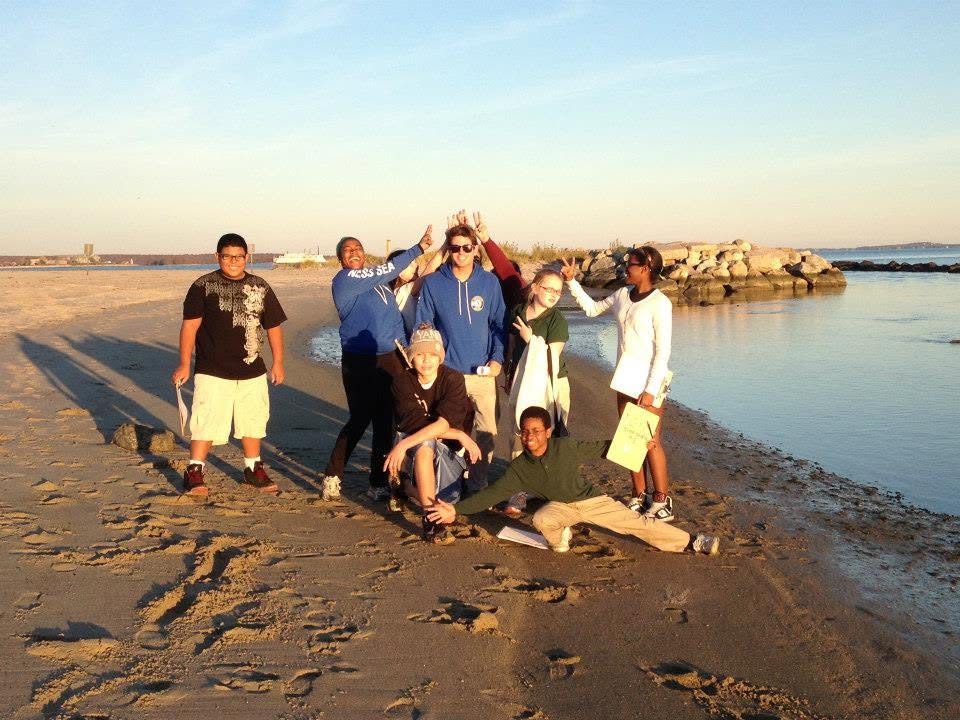 Student group posing on the beach at sunset
