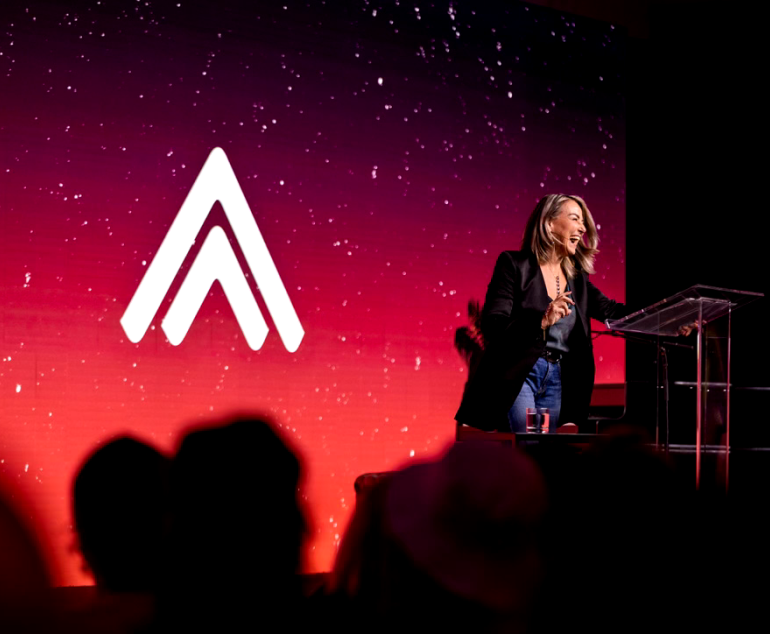 Speaker on stage at a Summit gathering